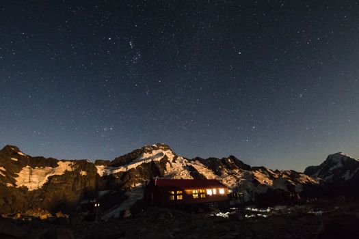 在新西兰库克山国家公园，山间小屋明亮，星空璀璨