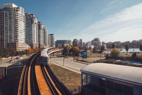 Free Capture of Vancouver SkyTrain passing by Science World with city skyline. Stock Photo