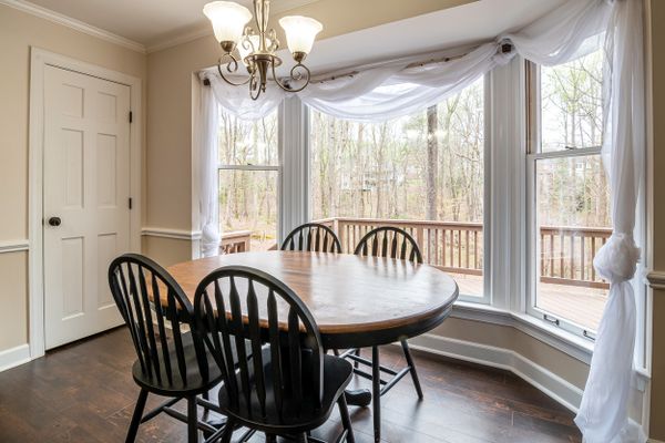 Breakfast table in a bay window looking onto the garden — photo by Curtis Adams on Pexels