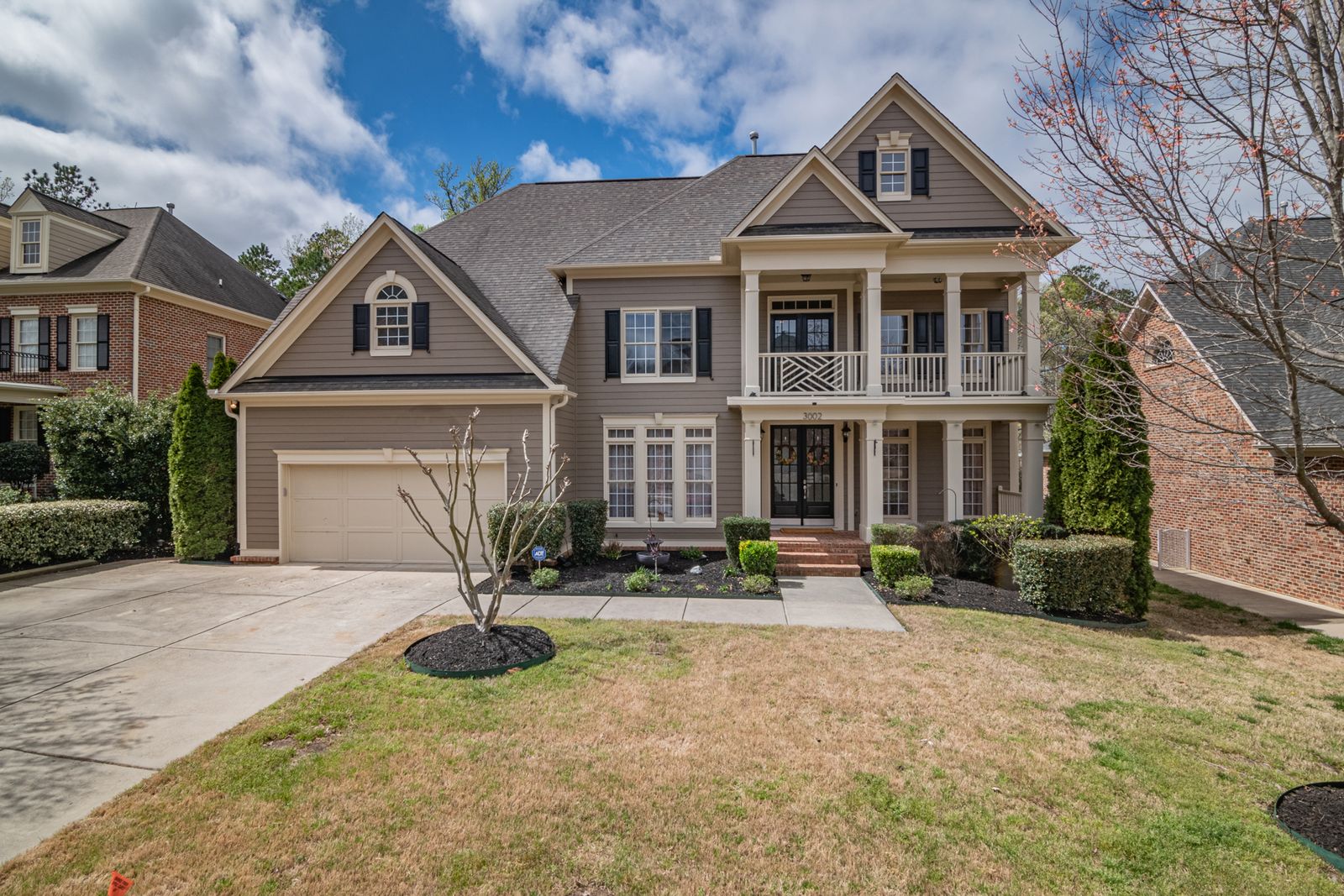 Two-story custom home with siding and brick and a two-story entry portico on a landscaped lot, University Heights, Naperville IL