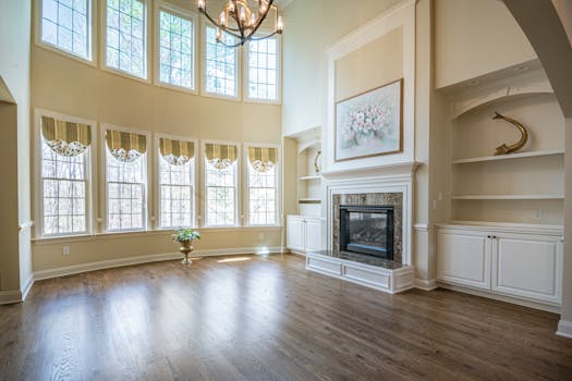Spacious living room with towering windows and elegant fireplace, perfect for stylish decor.
