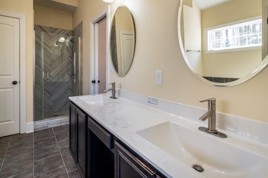 Elegant bathroom with dual sinks, large mirrors, and a spacious shower.