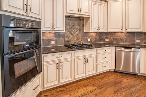 Free A modern kitchen featuring cabinets, a dishwasher, and a double oven with hardwood floors. Stock Photo