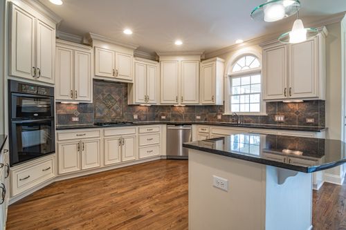 Free A spacious, modern kitchen with white cabinetry and a sleek black countertop, perfect for culinary enthusiasts. Stock Photo
