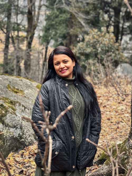 Free Smiling woman in a black jacket amidst a serene autumn forest setting. Stock Photo