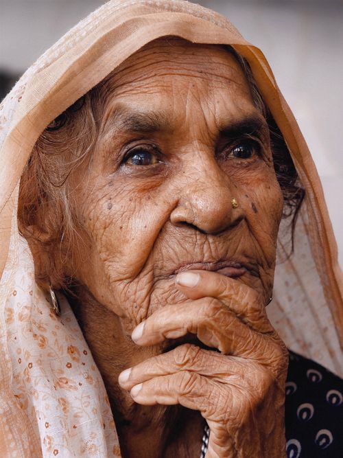 Free Close-up portrait of an elderly woman deep in thought, highlighting wisdom. Stock Photo