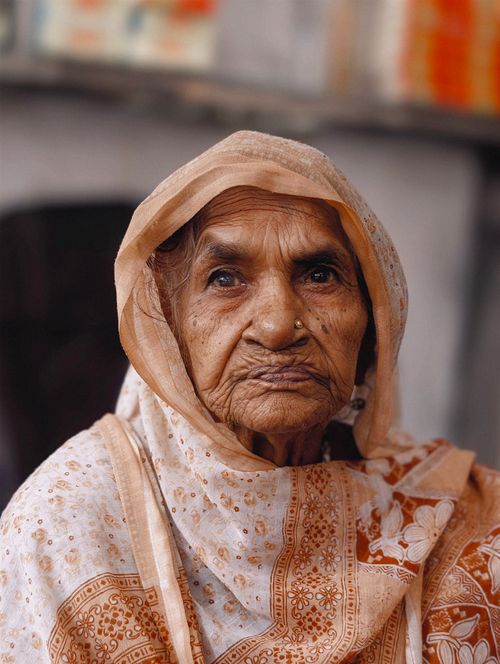 Free Elderly woman wearing a shawl with a peaceful expression indoors. Stock Photo