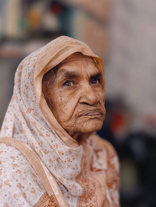 Free Close-up portrait of an elderly woman wearing traditional attire, conveying wisdom and history. Stock Photo