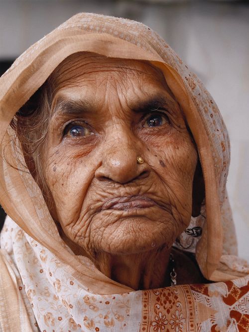 Free Close-up portrait of an elderly woman in traditional attire, showcasing expressions of wisdom and age. Stock Photo