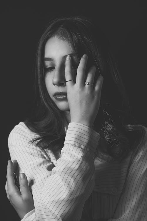 Grayscale Photo of Woman with Her Hand on Her Face