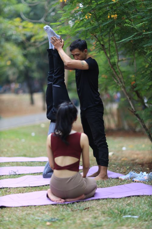 Free A yoga instructor assists a participant in headstand at a park in Jakarta, Indonesia. Stock Photo