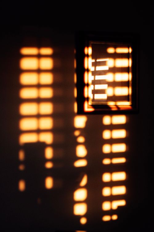 Free Sunlight creating high contrast patterns on a wall through window blinds. Stock Photo