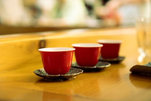 Free Artistic shot of three red ceramic cups arranged on a wooden table, perfect for cozy indoor settings. Stock Photo