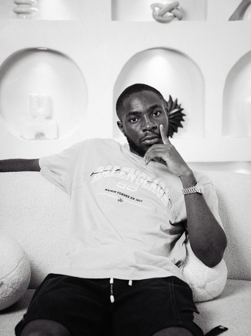 Free Black and white portrait of a thoughtful man lounging on a stylish white sofa. Stock Photo