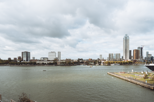 Free Scenic view of Rotterdam's modern skyline along the river under cloudy skies. Stock Photo