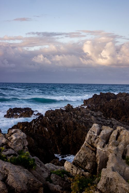 Free Rocky shoreline with waves and clouds in Cantabria, Spain at sunset. Stock Photo