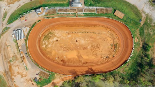 Drone view of bright open sandy pit near growing trees