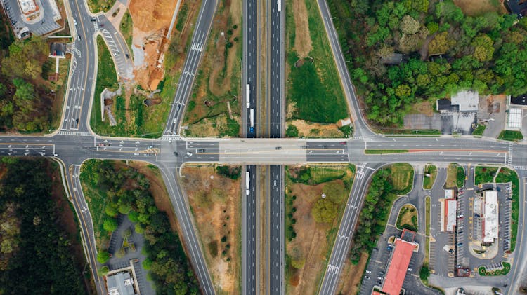 Asphalt Junction Near Greenery On City Street