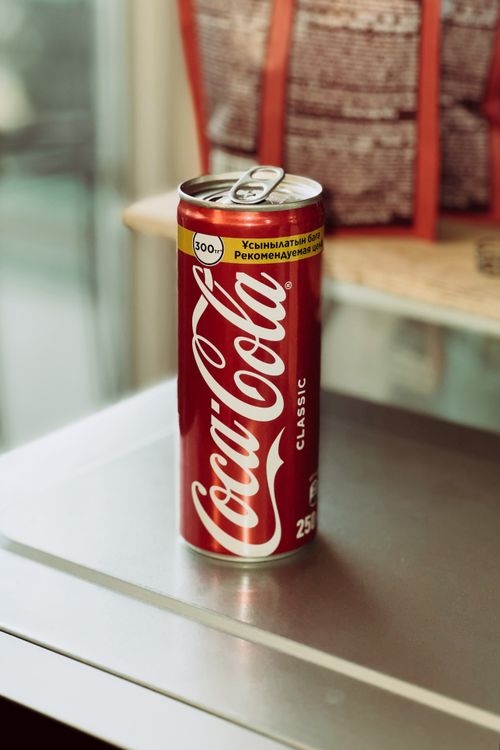Free Close-up of a classic Coca-Cola can on a metallic table indoors. Stock Photo