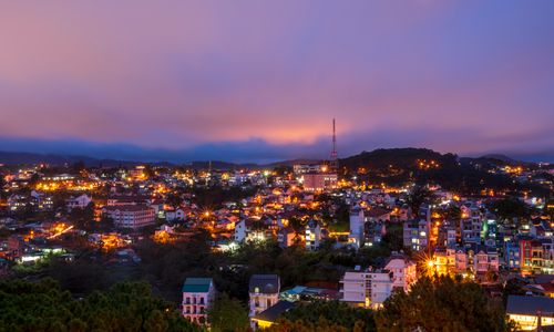 Free Beautiful twilight cityscape of Đà Lạt with vibrant lights and a colorful sky. Stock Photo