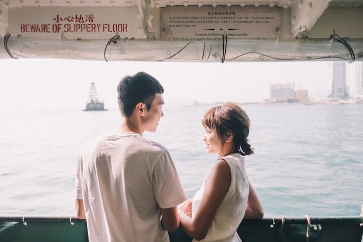 Young Asian Couple Standing On Yacht