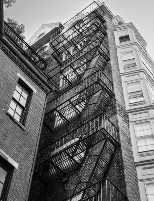 Free Black and white photo of a fire escape on a historic brick building in Boston, Massachusetts. Stock Photo