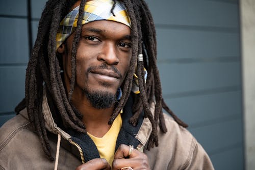 Positive African American man with dreadlocks on street