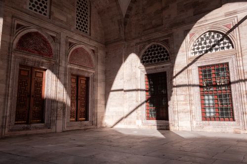 Free Sunlight casts patterns on a historic courtyard's stone walls in Istanbul, Türkiye. Stock Photo