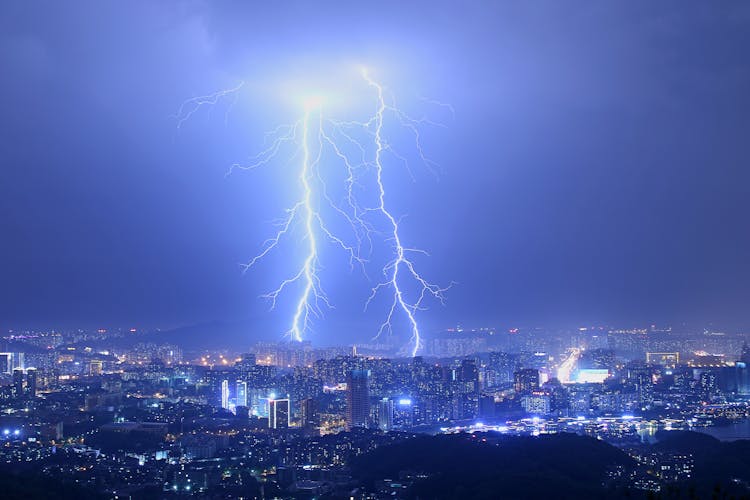 Cityscape With Thunderstorm Over Skyscrapers At Night