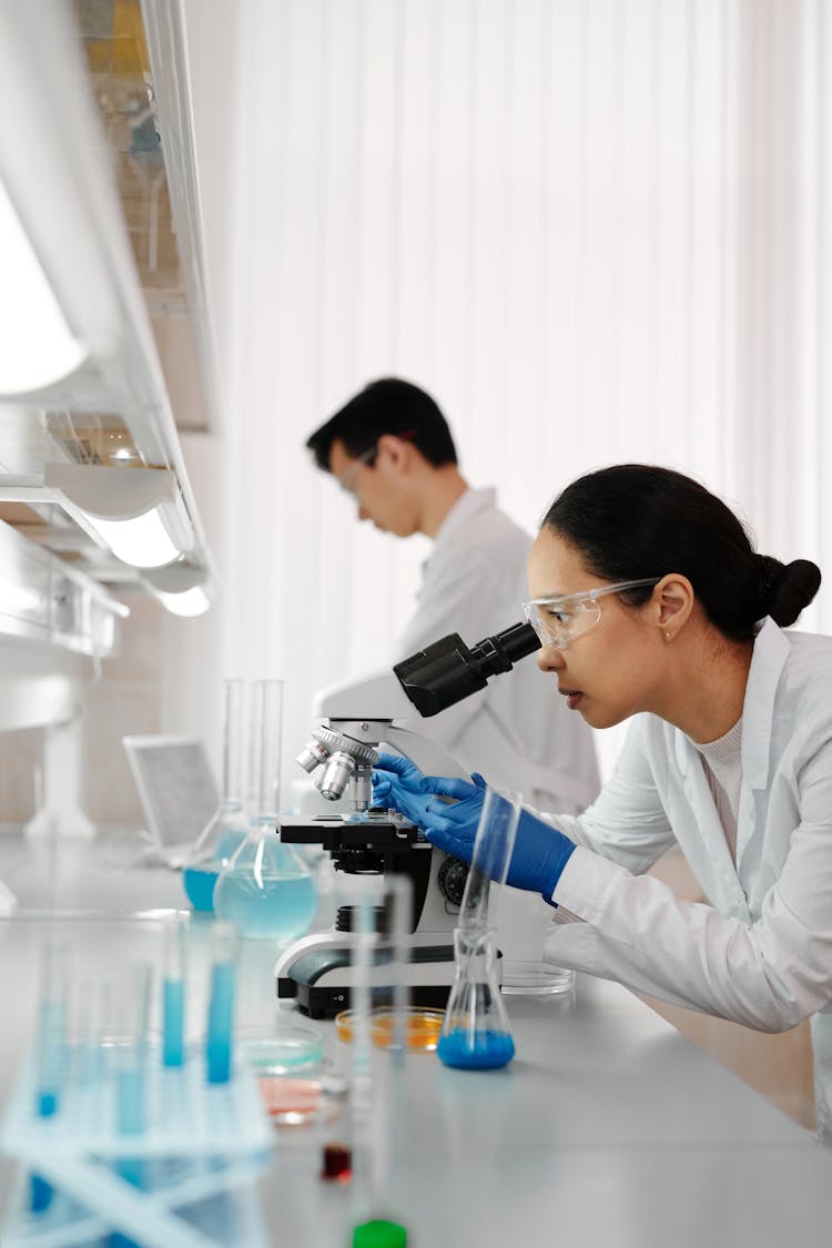 Woman Looking At A Microscope