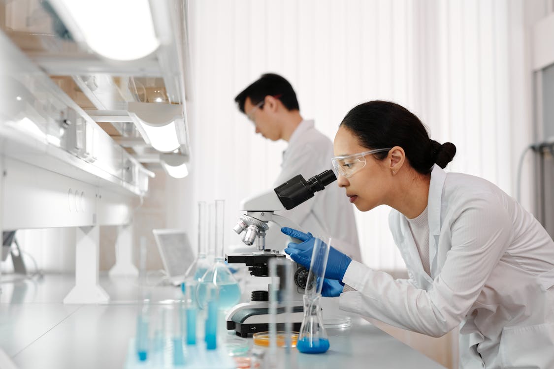 a clinician using a microscope to examine a specimen.