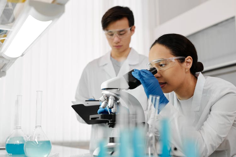 Woman Looking At A Microscope