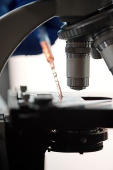 实验室环境中显微镜和移液管的详细视图，突出了科学研究