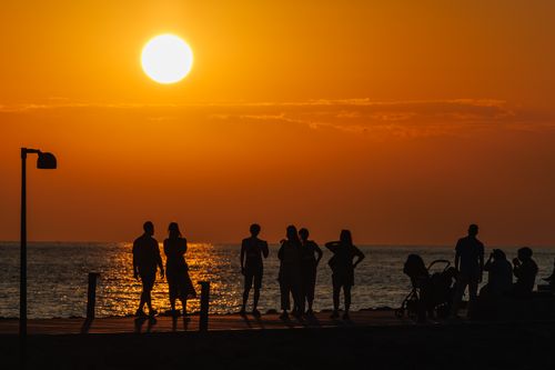 Free Silhouetted group of people enjoying a stunning sunset at Side Beach, Antalya, Türkiye. Stock Photo