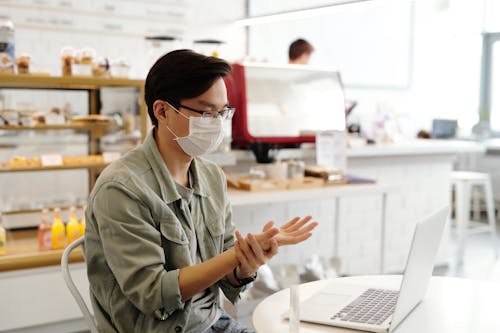 Free Photo of a Man with a Face Mask Holding His Wrist Stock Photo