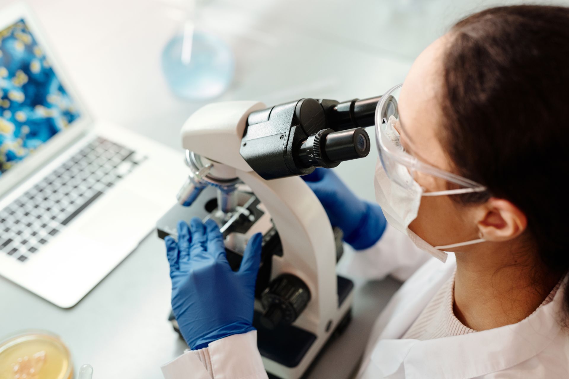 Researcher's hands working at a microscope in a laboratory