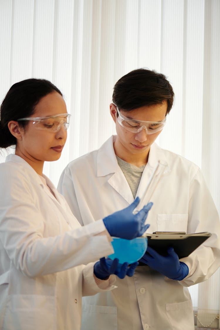 Two Scientists In White Lab Coats Doing A Research