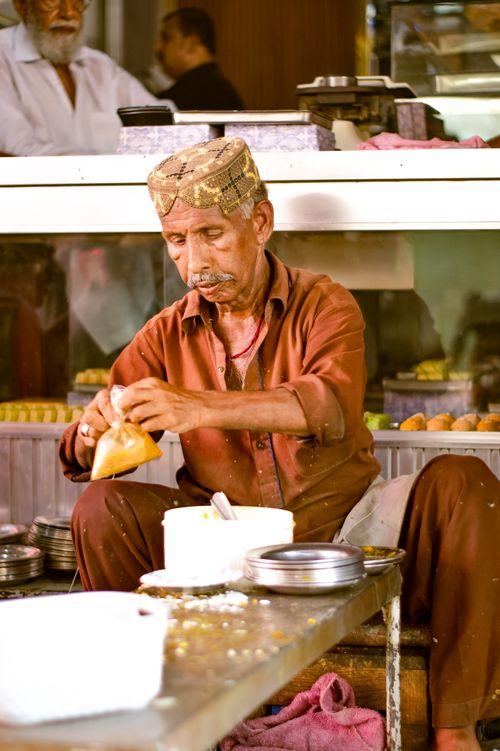 Free A street vendor skillfully prepares traditional sweets in a bustling market setting. Stock Photo