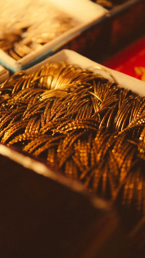 Free Detailed shot of golden bangles in warm lighting, showcasing intricate designs and rich color. Stock Photo