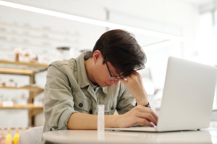 A Man Looking Sick While Working With His Laptop