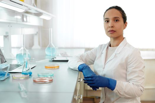 女科学家穿着实验室外套，用玻璃器皿进行研究