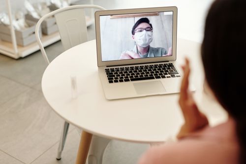 Free A person waving during an online video call meeting on a laptop. Stock Photo