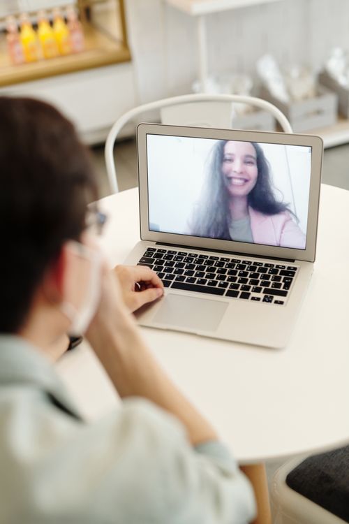 Smiling woman on a laptop screen during a video call, as in 100% Free Video Chat with Americans