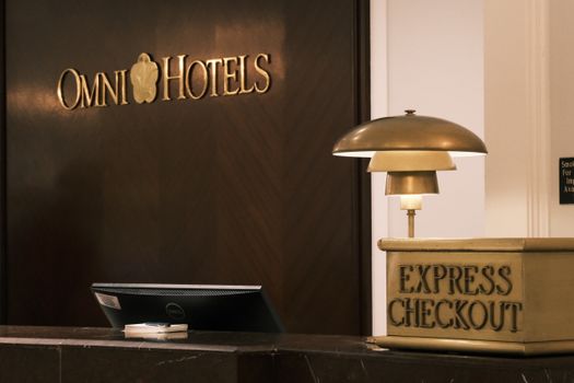 Elegant hotel lobby with an express checkout desk, lamp, and signage, conveying luxury and convenience.