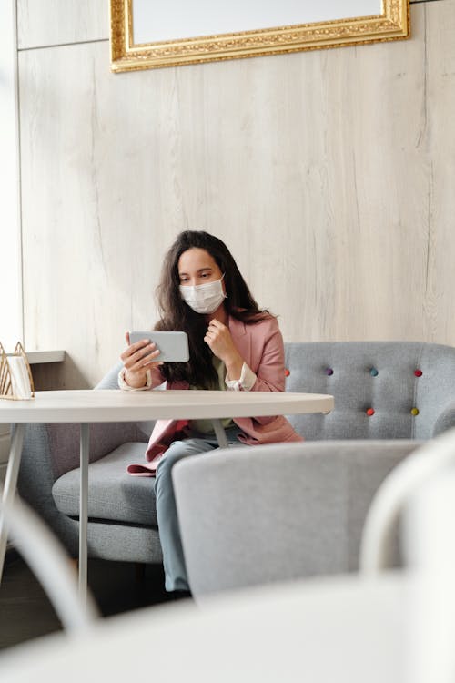 Woman Wearing A Face Mask While Sitted Using Her Phone