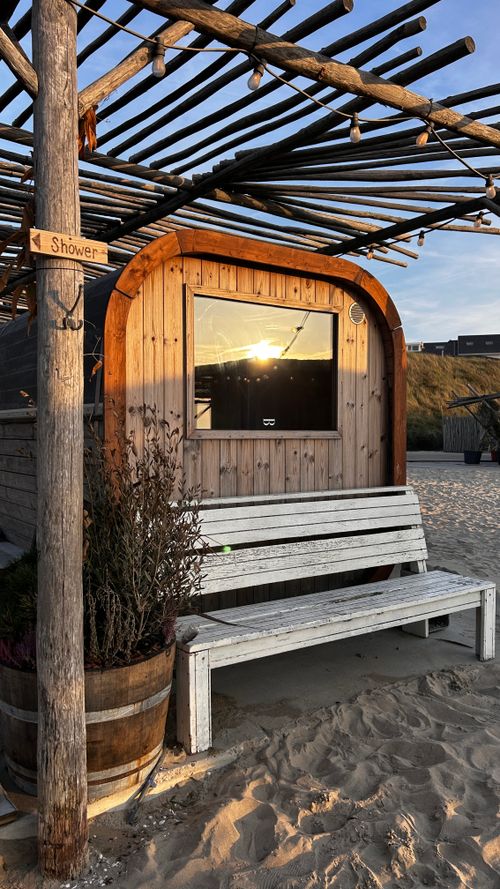 Free Charming wooden beach hut in Zandvoort with a sunset reflection, showcasing relaxed coastal architecture. Stock Photo