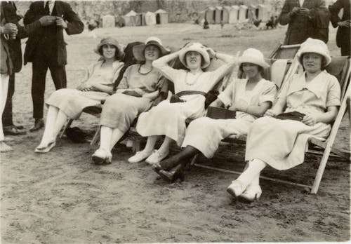 Grayscale Photo of  Women Sitting on A Folding Chair