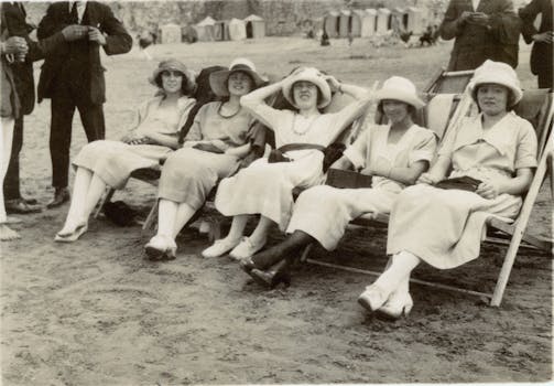 A nostalgic black and white photo showing women relaxing on a beach, embodying vintage leisure.