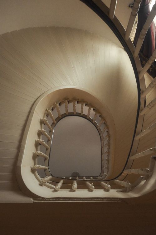 Free Stylish upward view of a swirling spiral staircase with elegant design elements. Stock Photo
