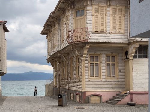 Free Charming historic building by the sea on a cloudy day with solitary figure. Stock Photo